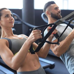 Full body workout: trainer demonstrating a trx row in a Dubai gym